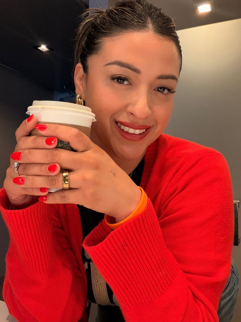Carol Vilchez-Smith smiling with a coffee in hand
