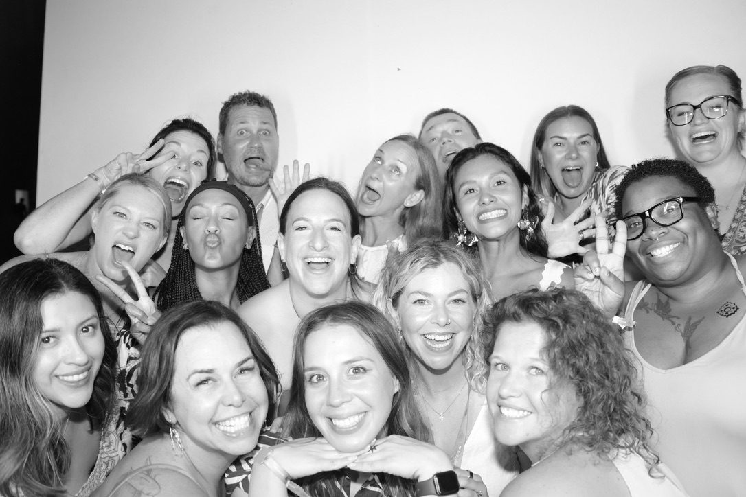 Carol and coworkers laughing together in a photo booth